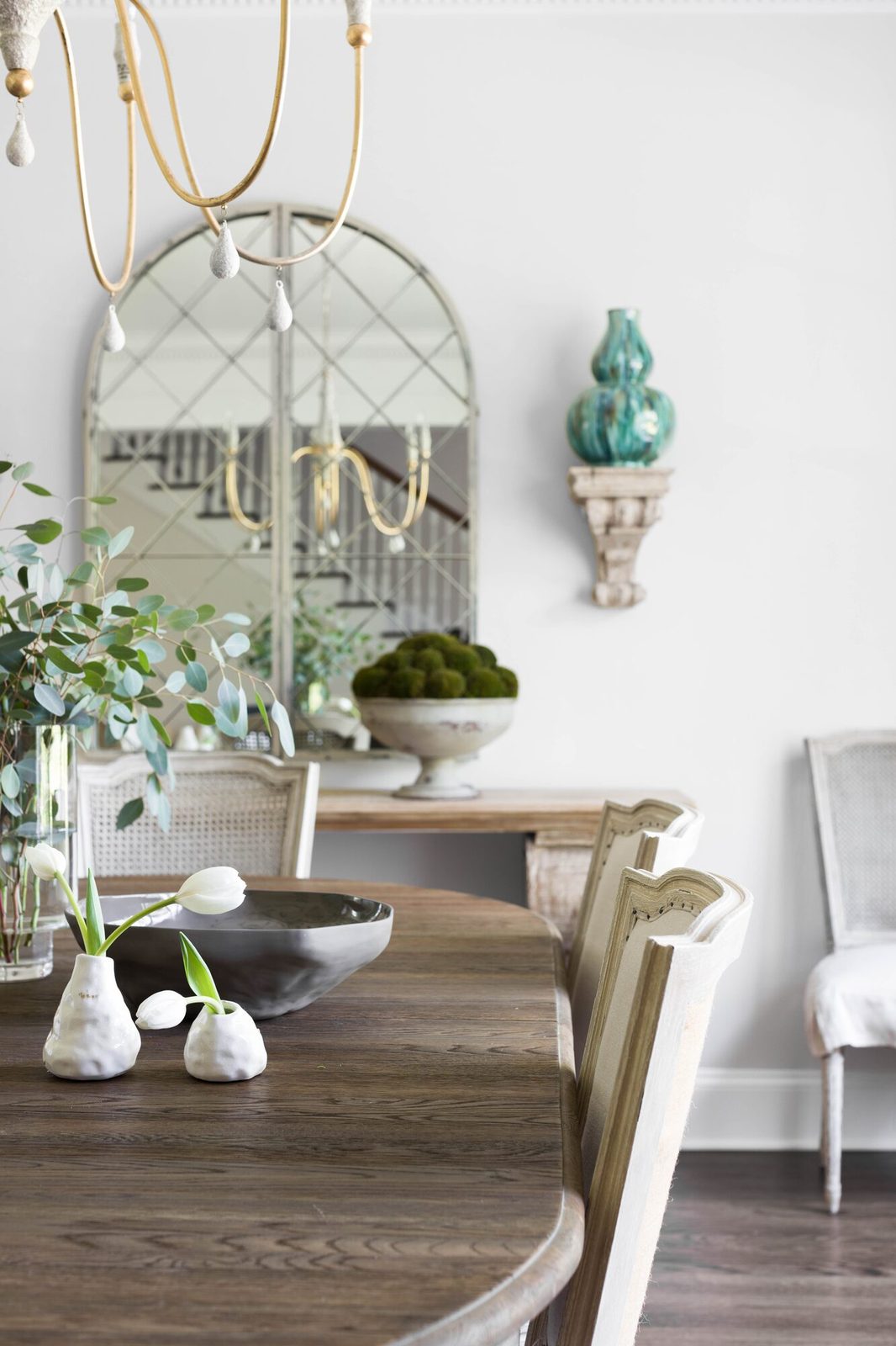 Interior design photography vignette of a dining room with arched mirror and styled tablescape: an example of a medium shot that highlights specific design moments