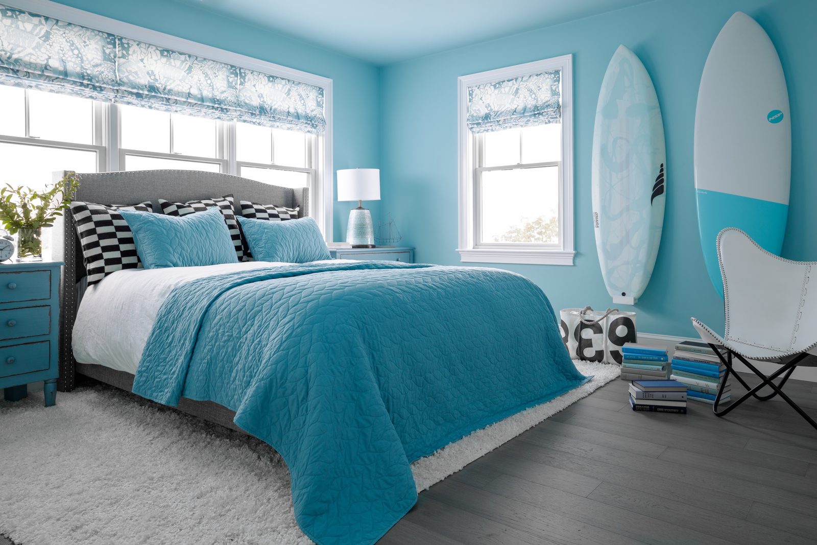 Wide-angle editorial interior photograph of an aqua-toned upstairs bedroom, the kind of establishing shot that anchors a website project gallery.