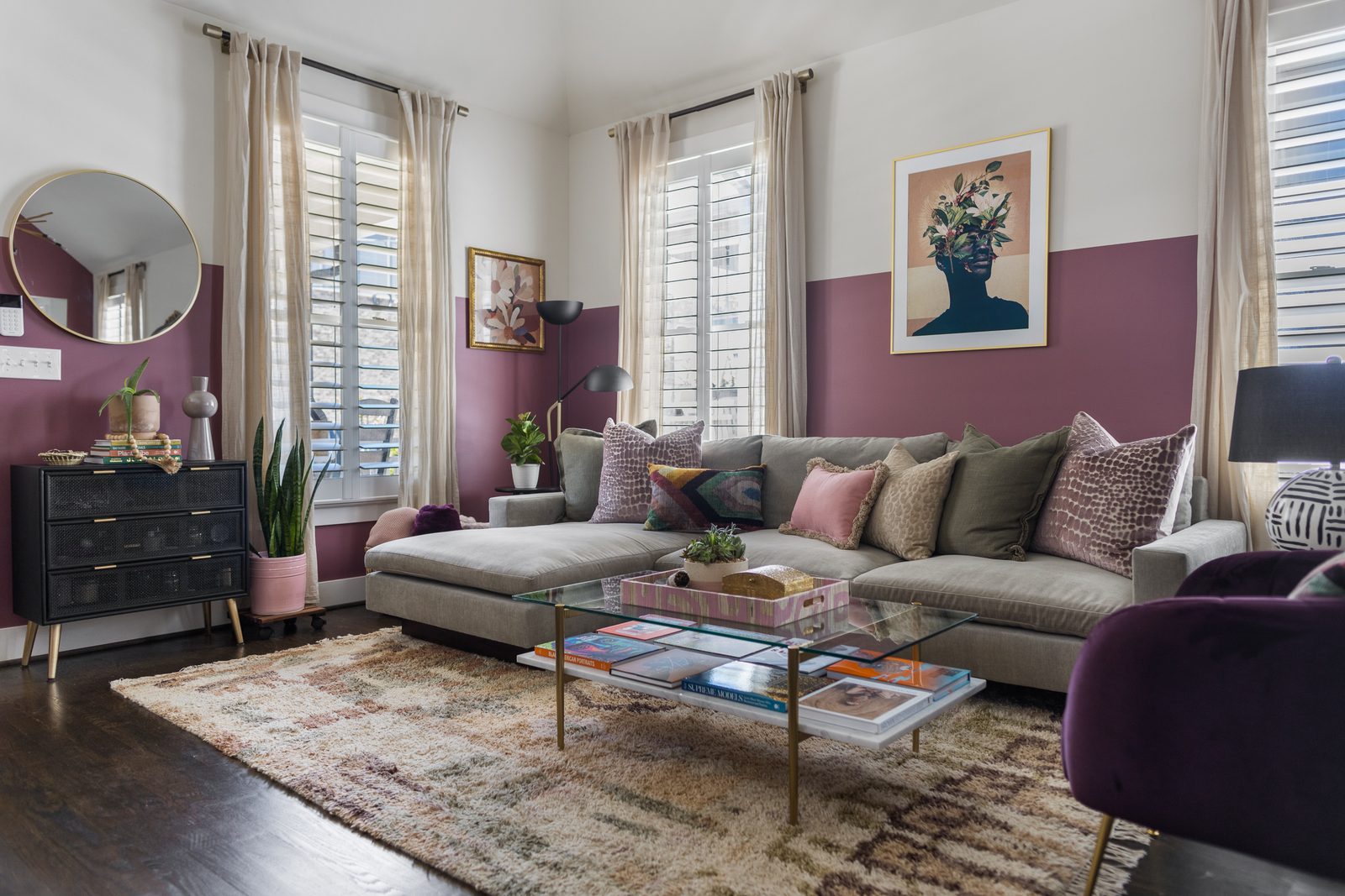 Color-blocked plum living room with a gray sectional, layered pillows, and a glass coffee table — a final frame where true-to-life color is exactly what the edit protects.