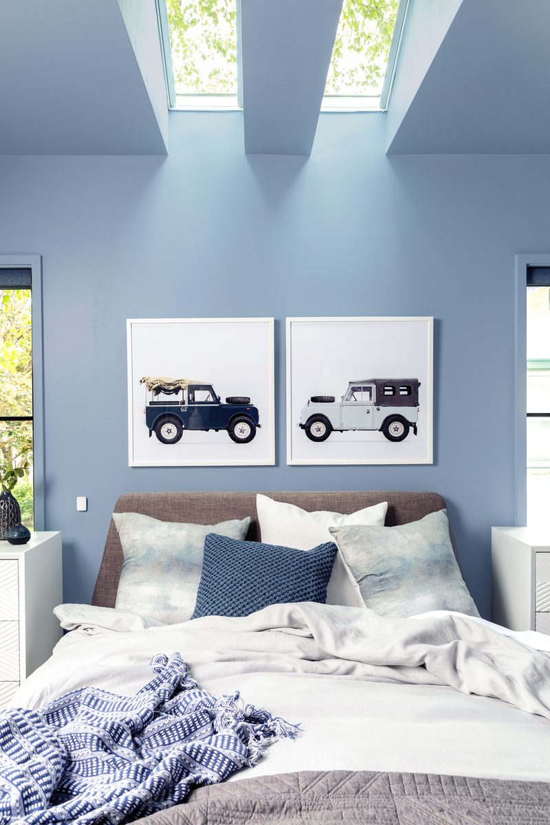 Vertical interior photograph of a master bedroom with skylights and soft daylight, editorial work showing the kind of styled bedroom imagery a designer typically licenses with a contractor or builder under a cost-share agreement.