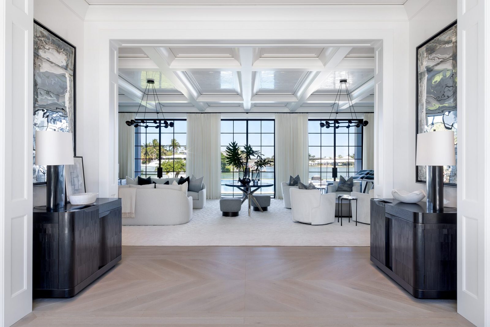 Wide editorial interior photograph of a grand living room with coffered ceiling, waterfront views, and carefully styled furnishings: an example of a hero shot from a professional interior design photography shoot