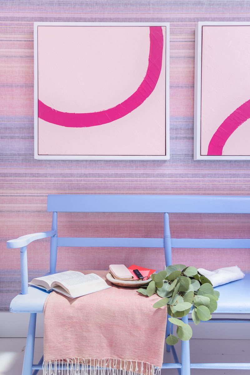 Carefully styled vertical detail shot of a blue bench with pink throw, open book, and abstract artwork, an example of intentional editorial styling for interior photography